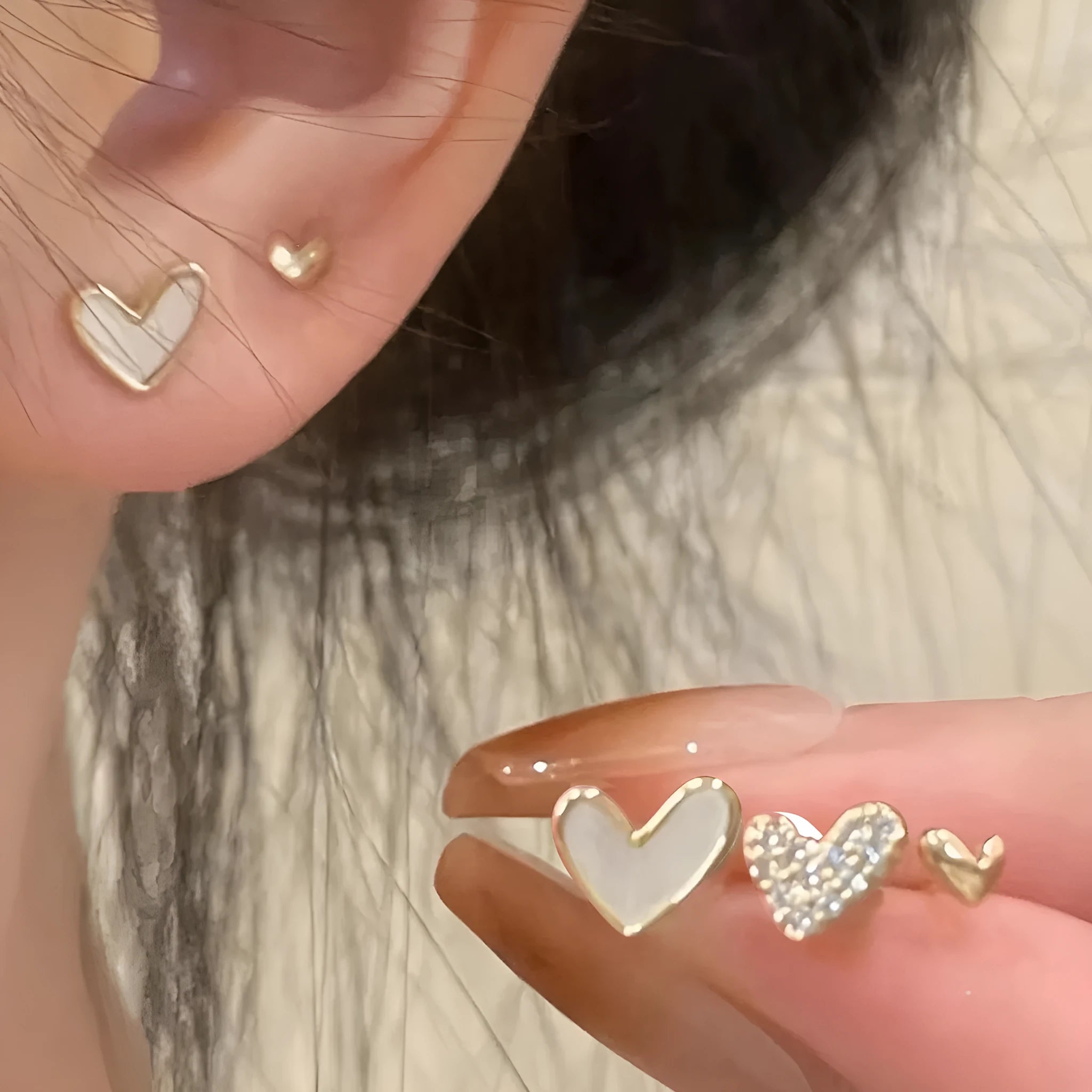 Three pairs of heart-shaped earrings with electroplated alloy construction in gold, black, pink and black-white colours