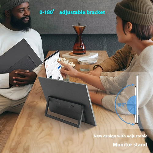 Black 15.6-inch portable computer monitor with adjustable stand on desk next to laptop