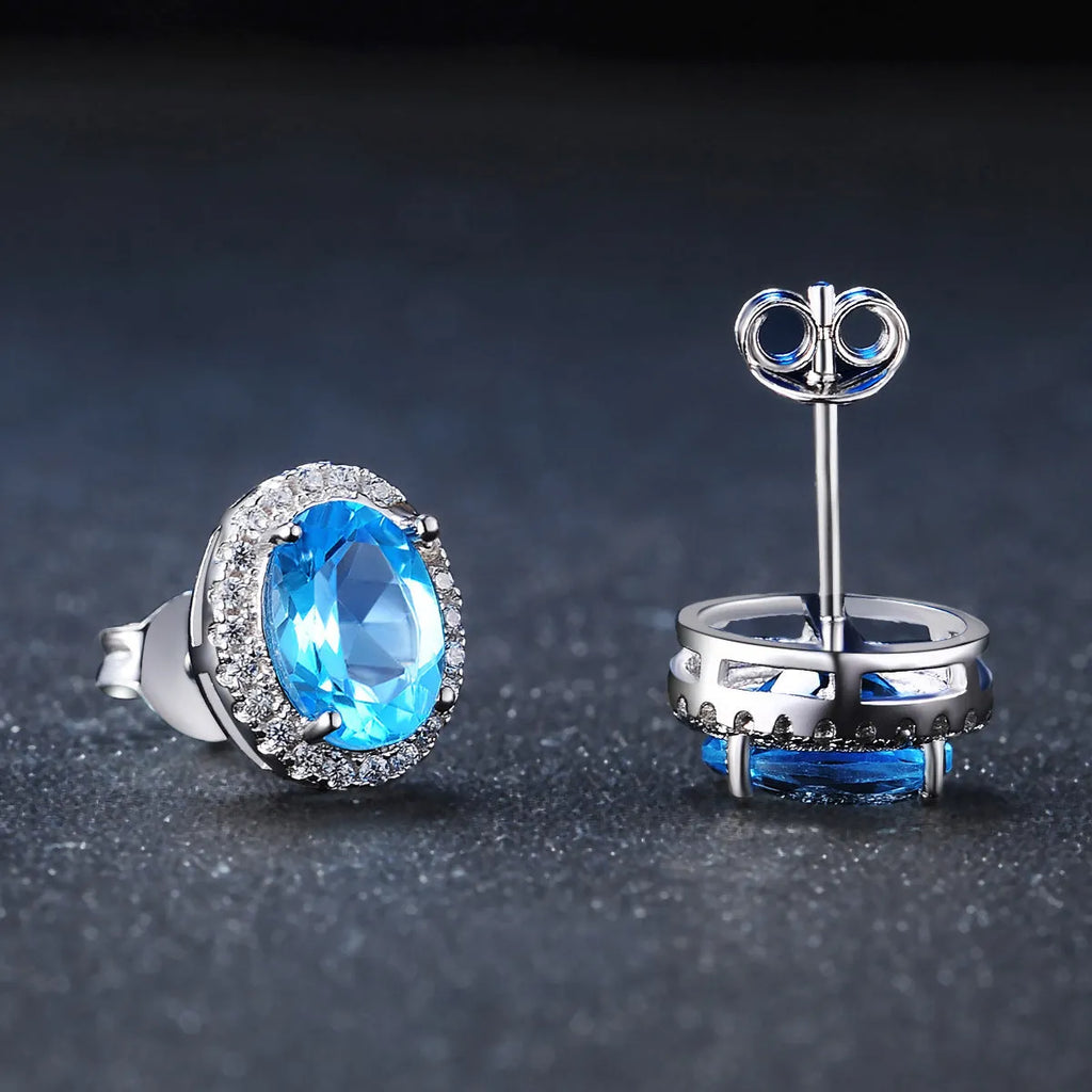 Four-piece 925 sterling silver jewellery set with blue topaz stones: geometric necklace, earrings, ring, and pendant.