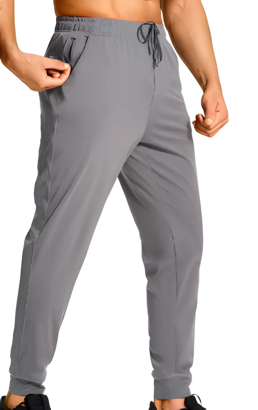 Men's loose-fitting casual polyester trousers in a solid colour on a hanger.