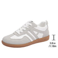 Women's retro grey jogging shoes with lace-up front and cross-strap detail on a rubber platform sole.