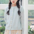 Women's cashmere cardigan sweater with bow and pearl buttons across chest in light blue colour