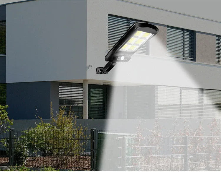 Black solar-powered outdoor motion sensor light mounted on a wall or post.