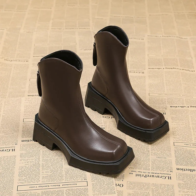 Women's black platform Martin ankle boots with a square toe, chunky sole, and back zipper.