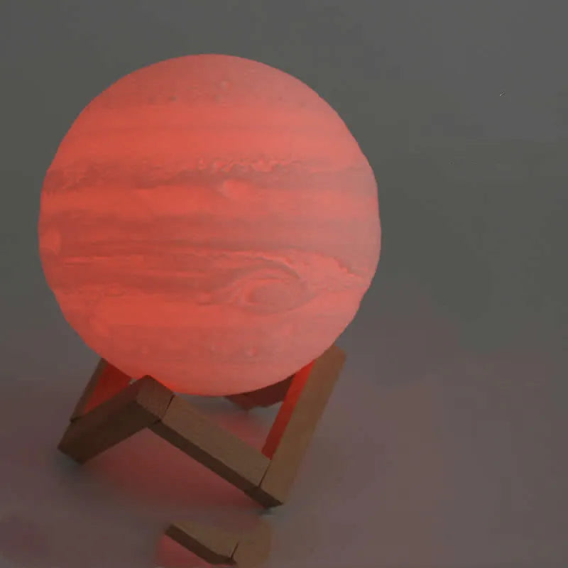 3D printed spherical moon lamp with textured surface on a wooden stand, showing white LED light.