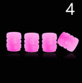 Pack of multicolour LED luminous tyre valve caps on a car wheel valve stem.