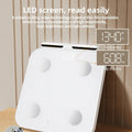 White professional body fat scale with 8 electrodes on tempered glass platform, LED display showing weight measurement