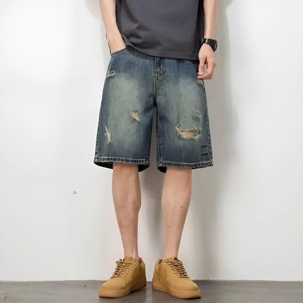Men's blue denim shorts with loose hole distressing and straight leg silhouette