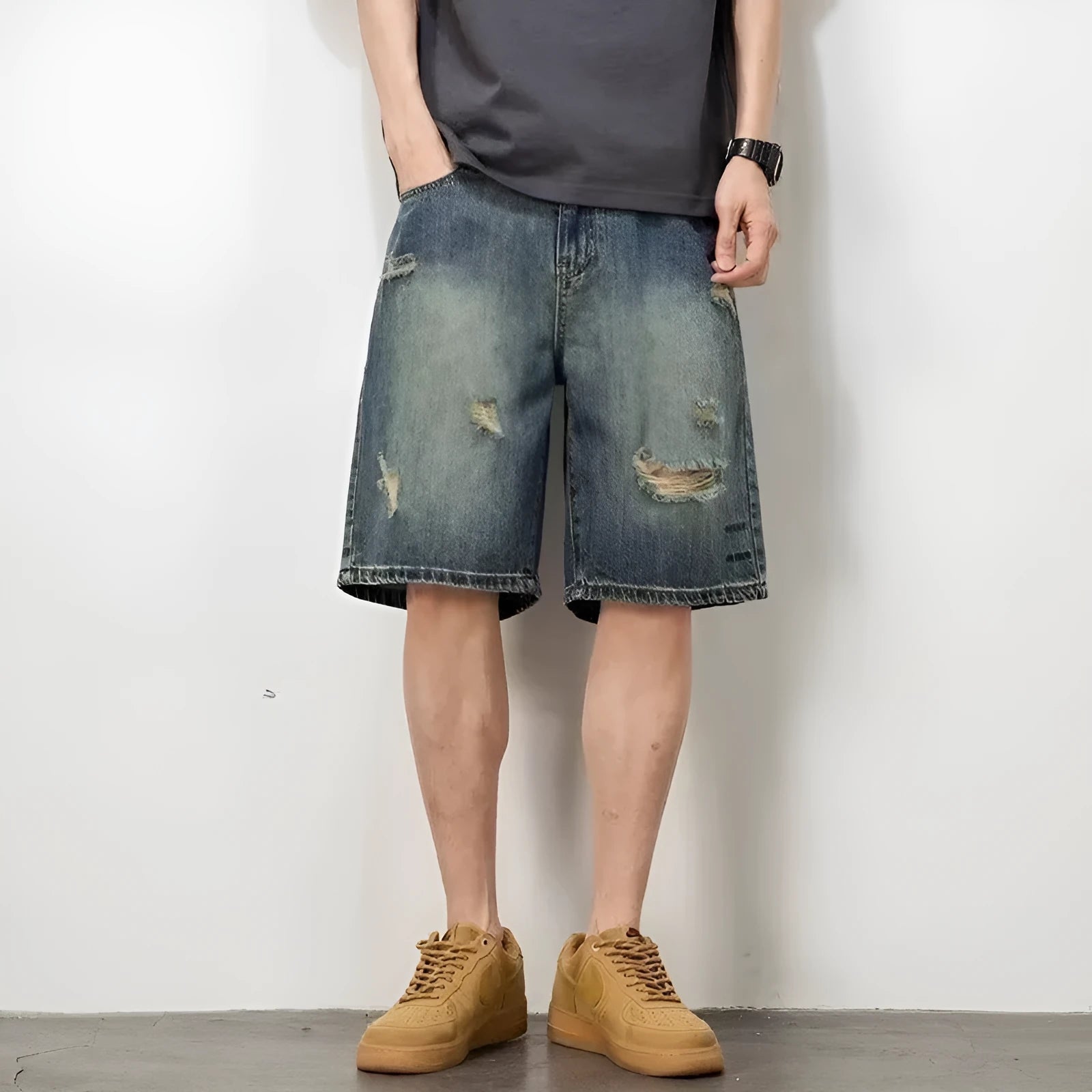 Men's blue denim shorts with loose hole distressing and straight leg silhouette
