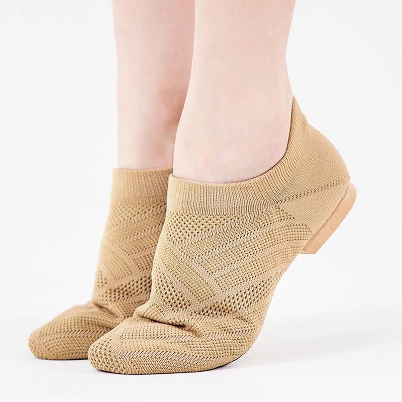 Camel colour dance yoga shoes with cotton mesh upper and leather sole on a plain background.