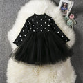 Baby girl wearing a long sleeve lace and tutu dress in pink, suitable for a birthday party.