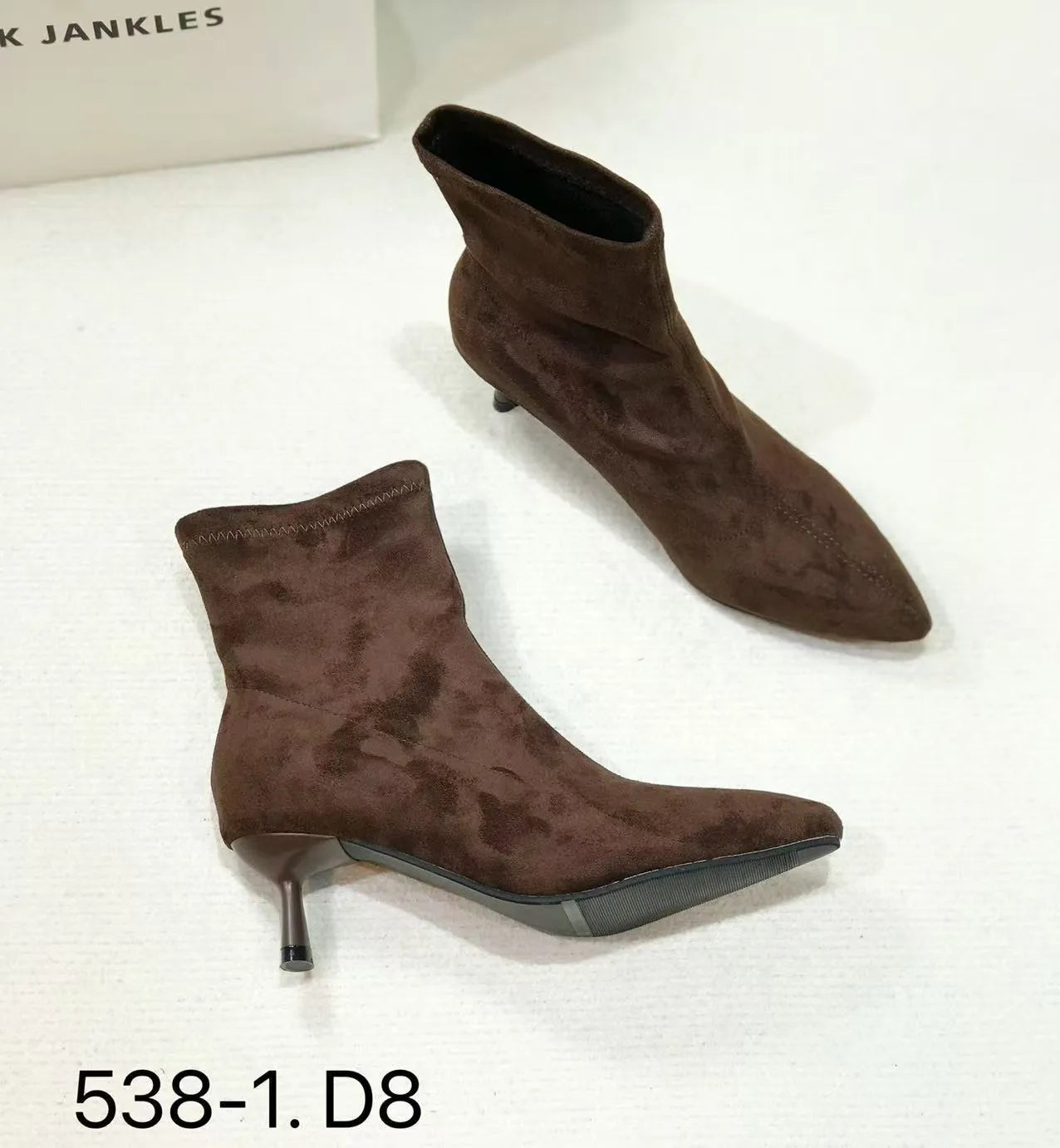 Black pointed toe women's ankle boots with a stiletto heel on a plain background.