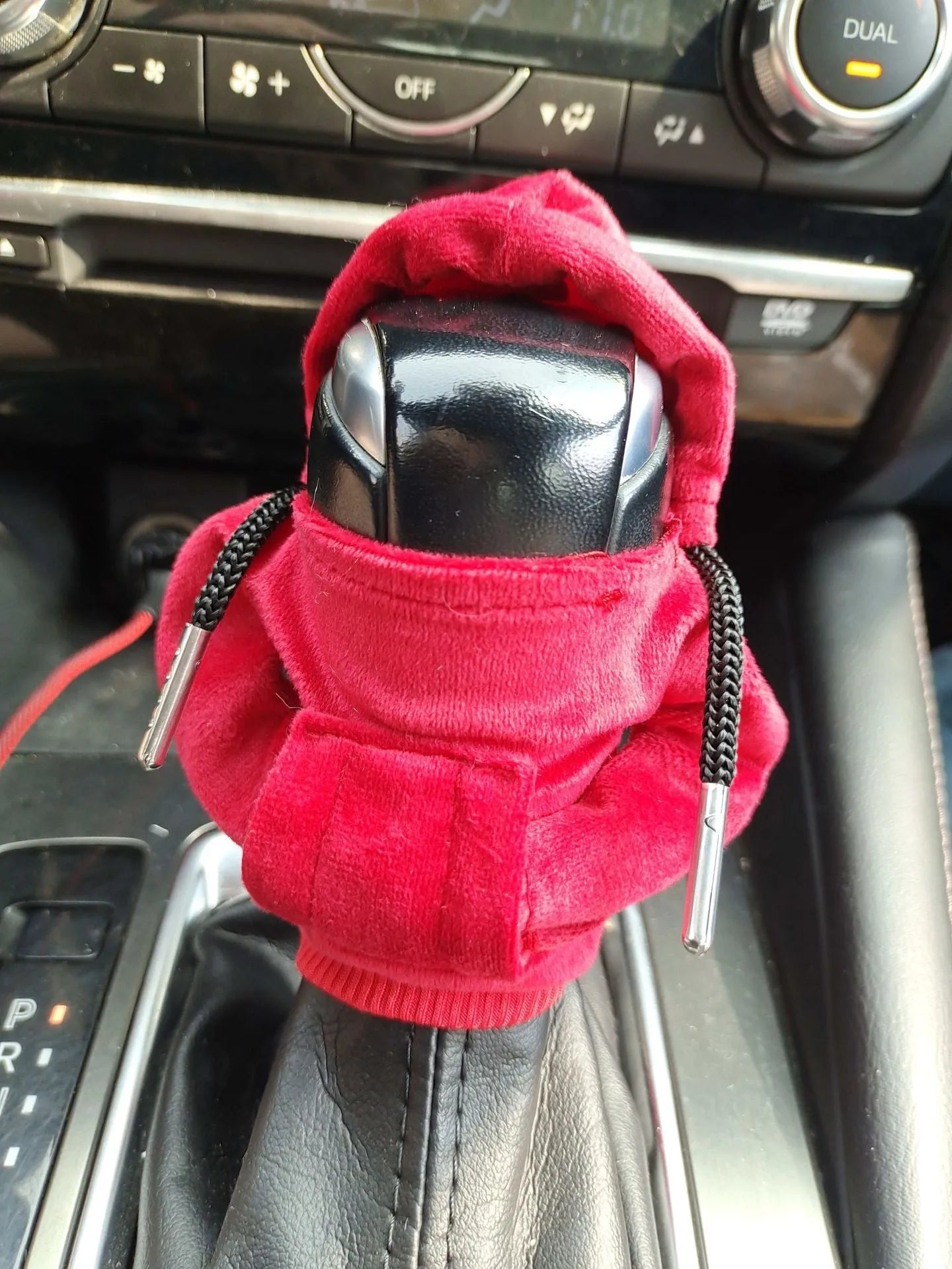 Pure cotton knitted gear lever sweater decoration in assorted colours on a car gear stick.