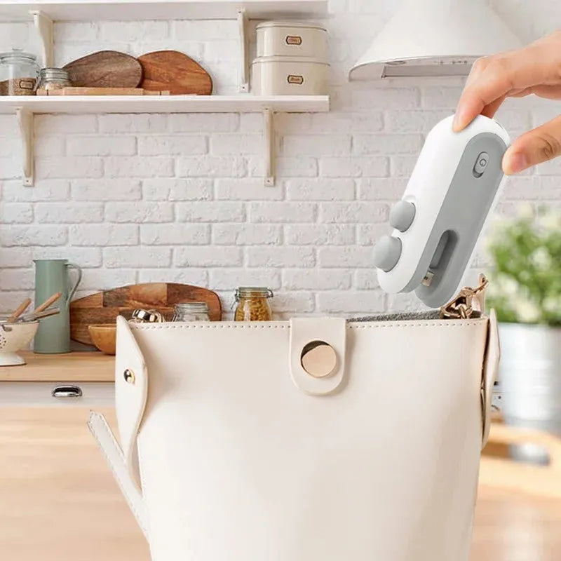 White handheld bag sealer with USB charging port and cutter blade for food storage