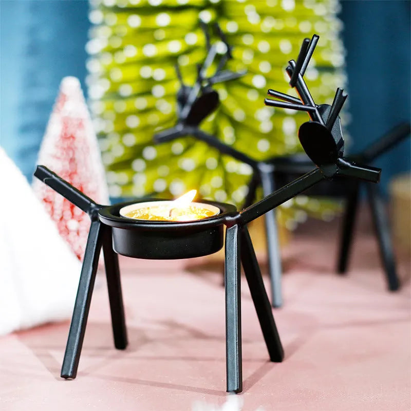 Black iron deer-shaped candlestick holder with fabric decorative elements for Christmas table decoration.