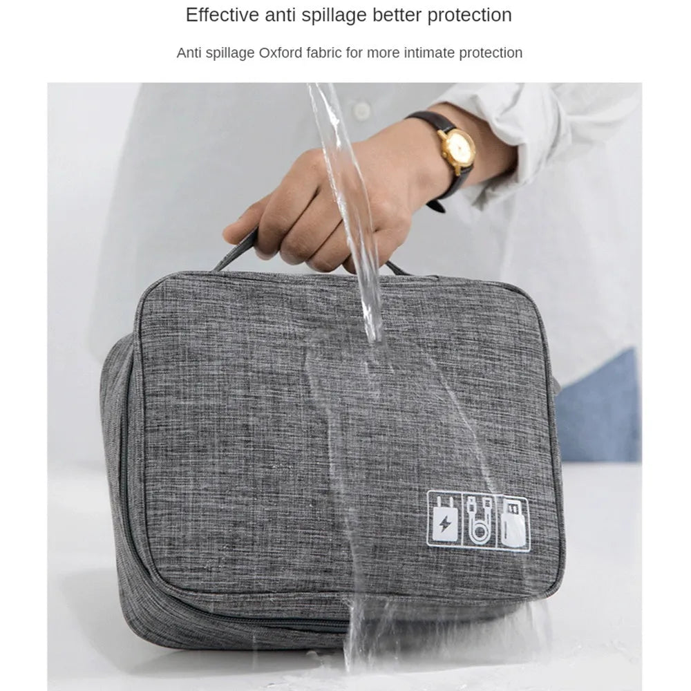 Black and grey waterproof electronics organiser bag open to show removable dividers and mesh pockets for cables.