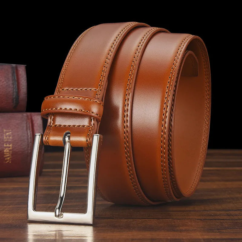 Men's black genuine leather belt with a silver alloy pin buckle on a flat surface