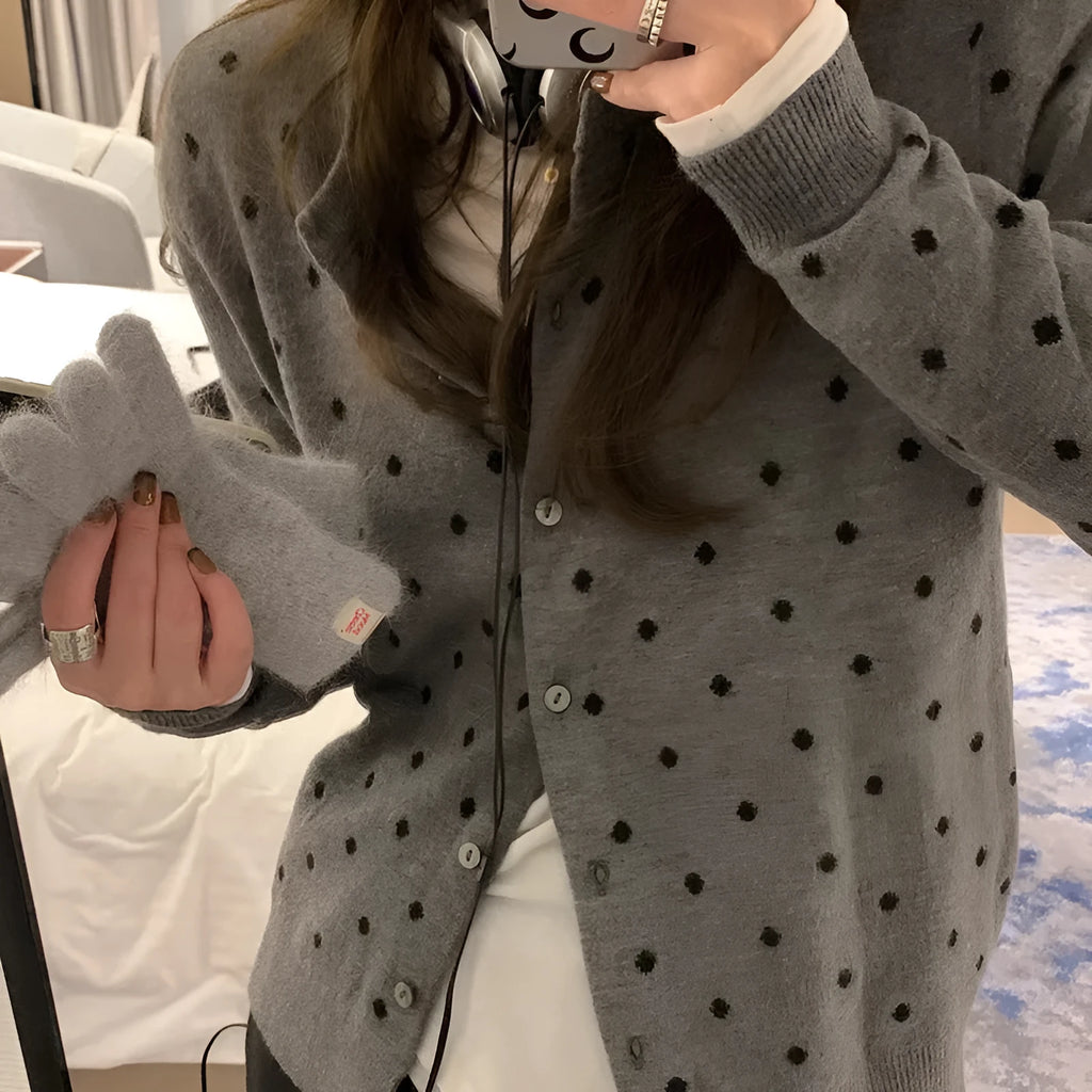 Women's loose fit grey knitted cardigan with crocheted flower details on the front.