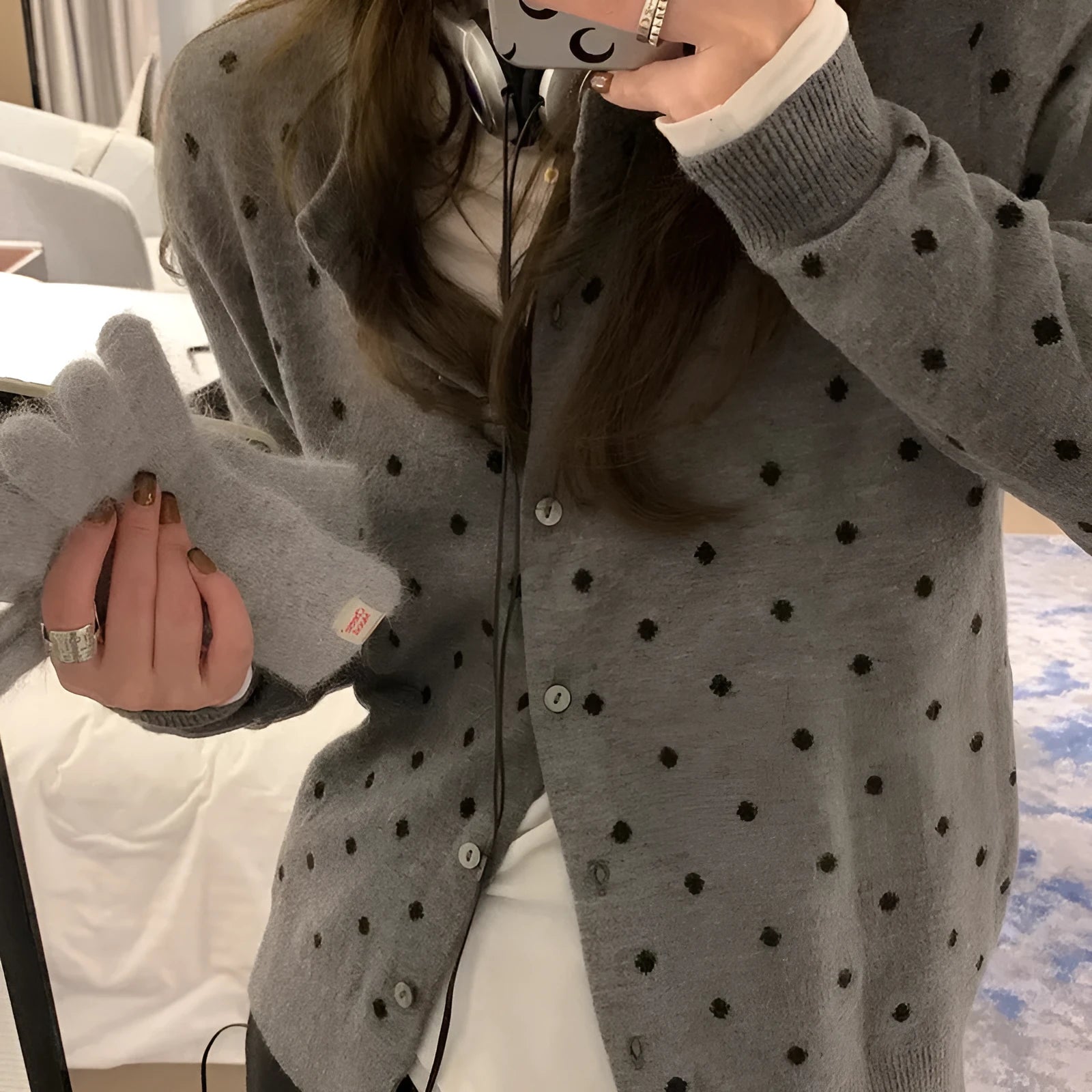 Women's loose fit grey knitted cardigan with crocheted flower details on the front.