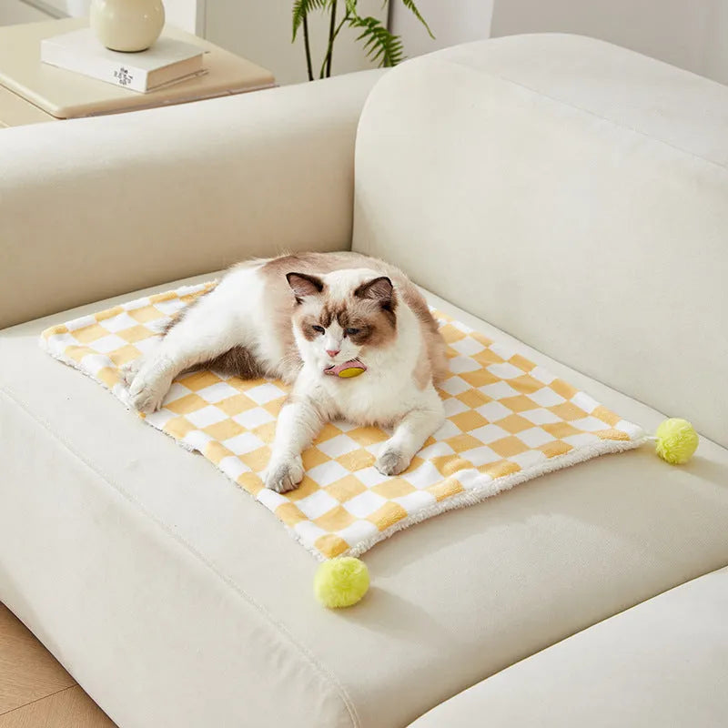 Plush cotton fleece pet blanket with plaid pattern and fur balls in green colour on couch