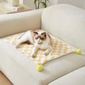 Plush cotton fleece pet blanket with plaid pattern and fur balls in green colour on couch