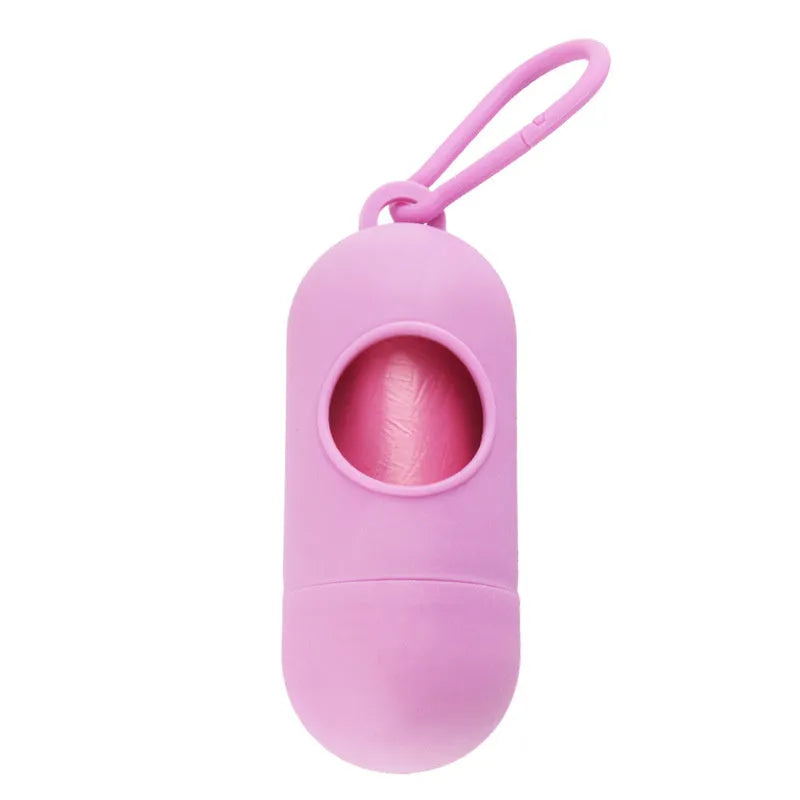 Compact black dog waste bag dispenser with a metal hook and Velcro strap, shown attached to a dog lead.