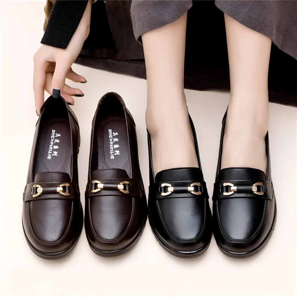 Black leather pumps with soft rubber soles, microfibre upper, and low flat heels on a white background