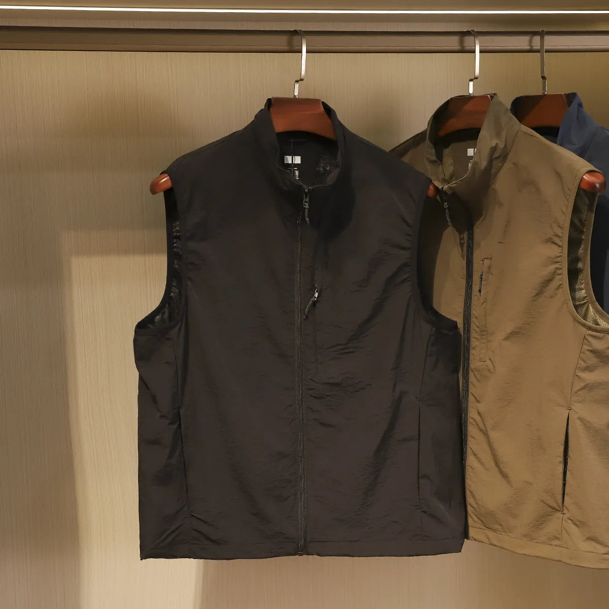 Men's thin nylon vest in straight cut with side pockets, shown in Army Green colour.