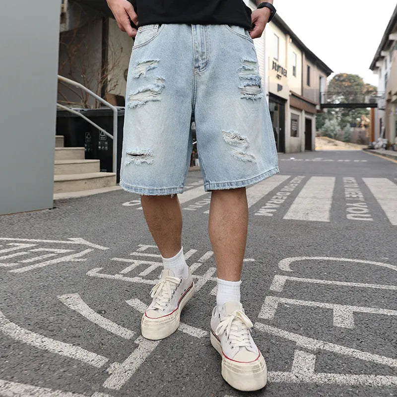Light blue distressed denim shorts with ripped detailing and straight cut hip hop style