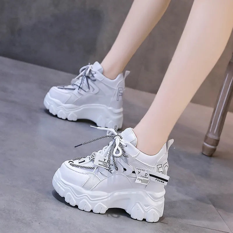 Women's white and black mesh platform tennis shoes with cross strap and thick rubber sole.