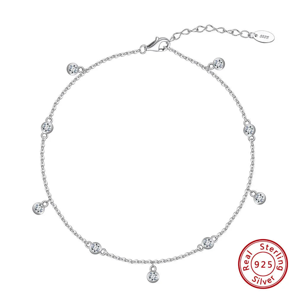 Simple silver anklet with a geometric zirconium pendant in gold colour