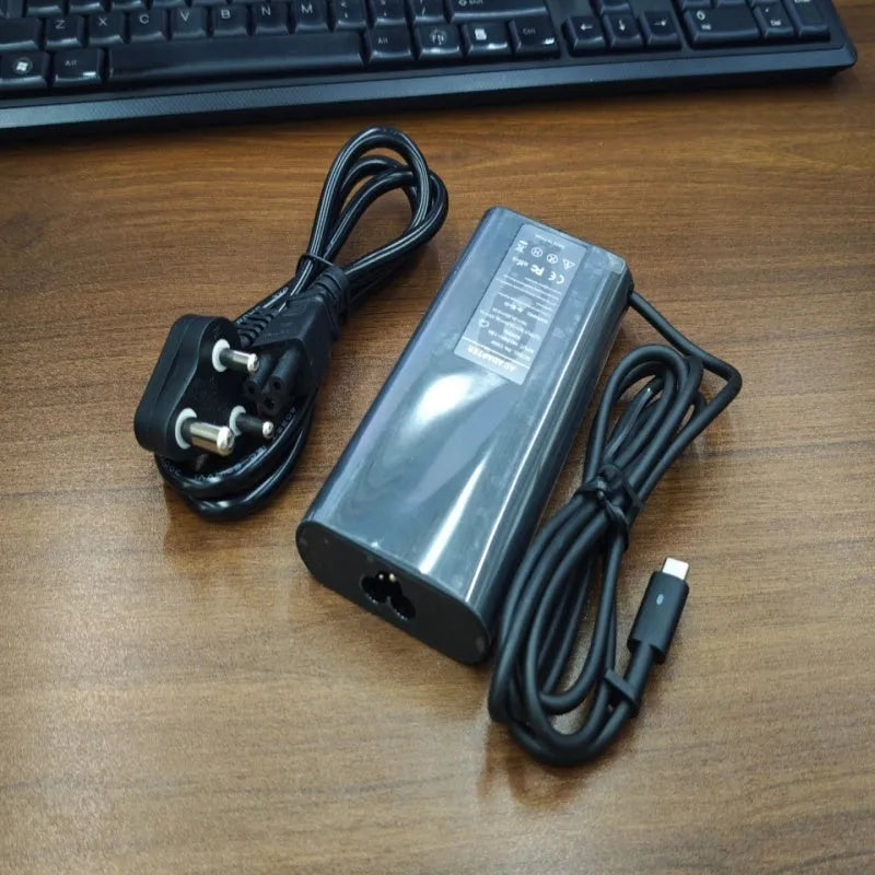 Black 65W USB-C laptop power adapter with six international travel plug cords.