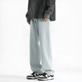 Men's light blue straight leg jeans with button waist closure on size chart background