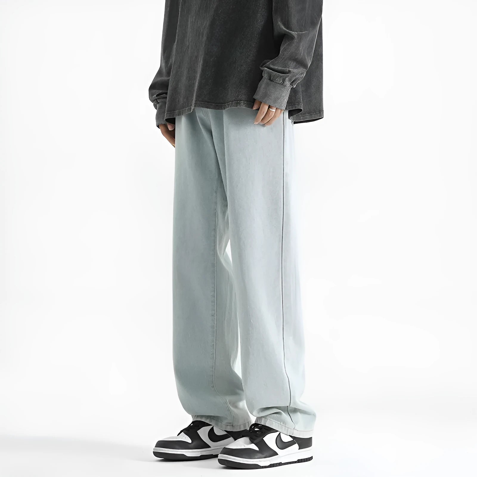 Men's light blue straight leg jeans with button waist closure on size chart background