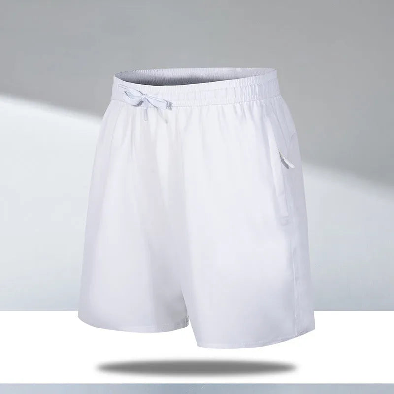 Man wearing loose fit black quick-dry sports shorts on a beach.