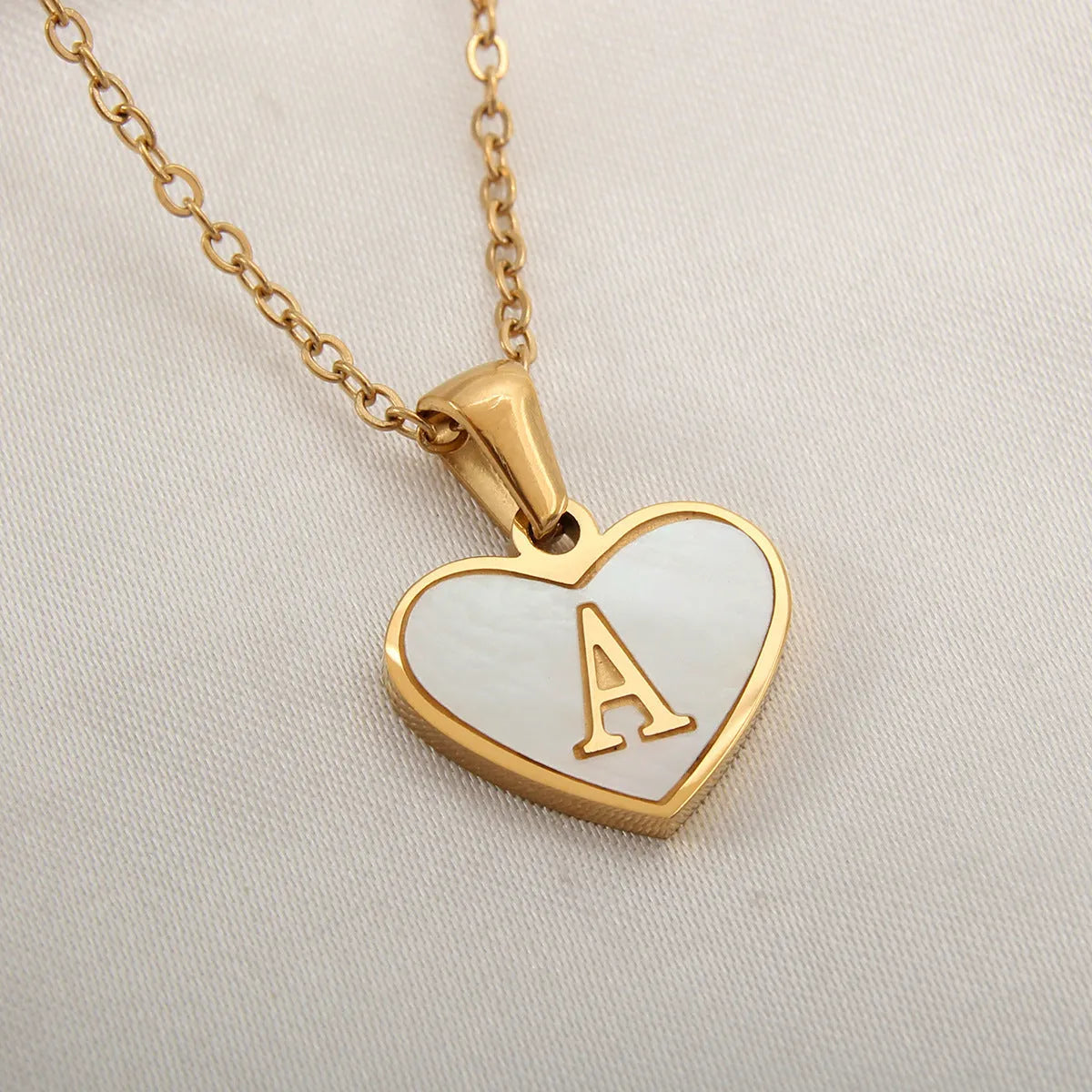 Gold heart necklace with white shell detail and personalised initial letter on adjustable chain
