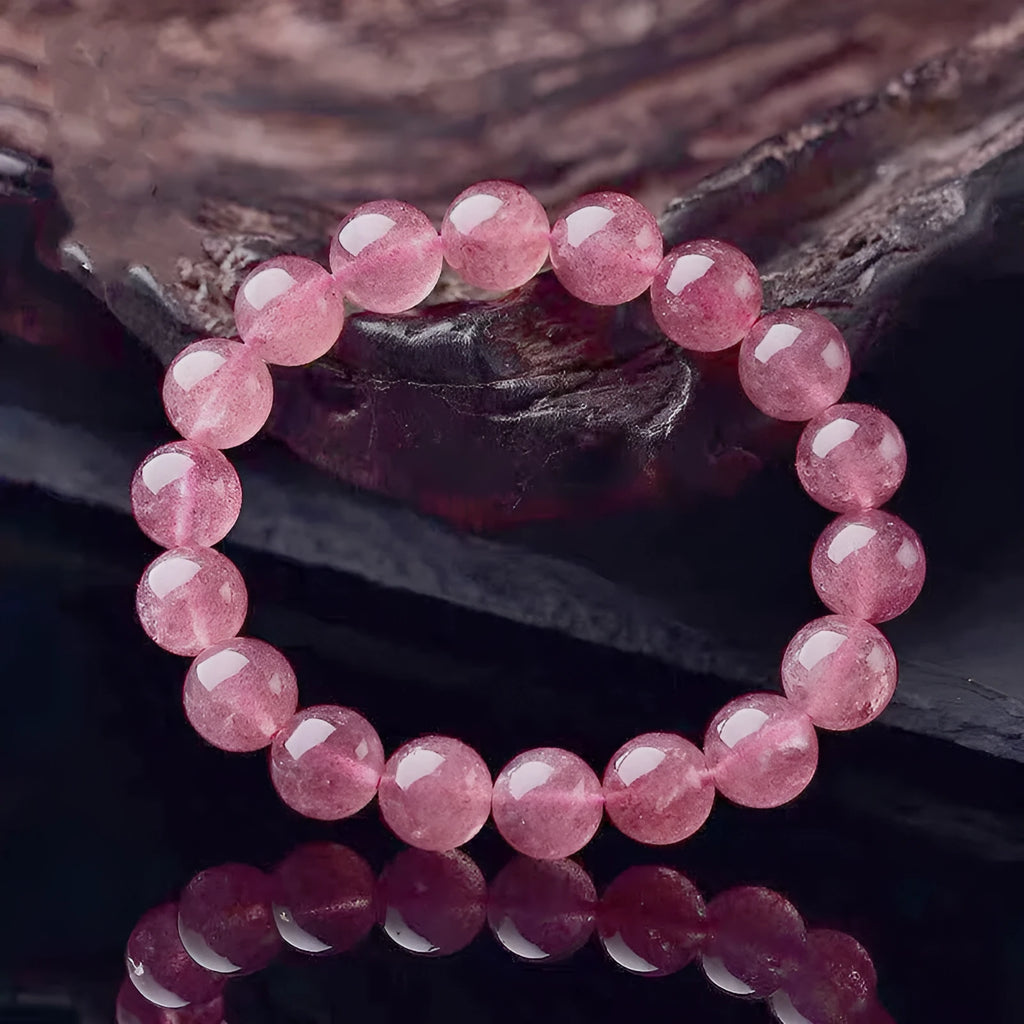 Women's bracelet with round, polished strawberry quartz crystal stones in natural pink tones.