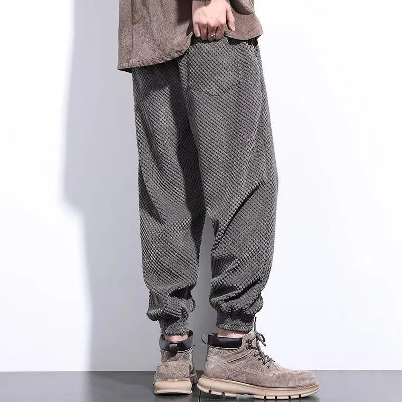 Men's grey ankle-tied straight leg sweatpants with elastic waist on a white background.