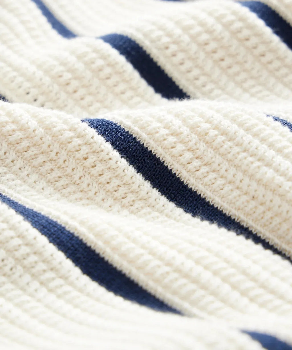 Men's white short sleeve knitted t-shirt with a lapel and asymmetric design detail.