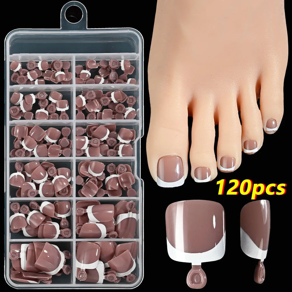 Box of 120 French white edge nude false toe nail pieces in assorted shades on a table