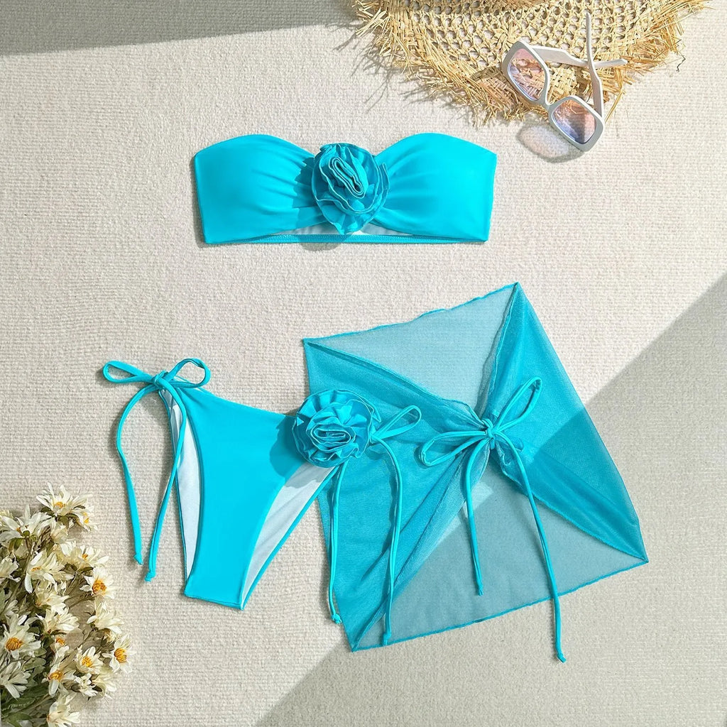 Women's pink tie-front tube top bikini set with large 3D flower and matching skirt.
