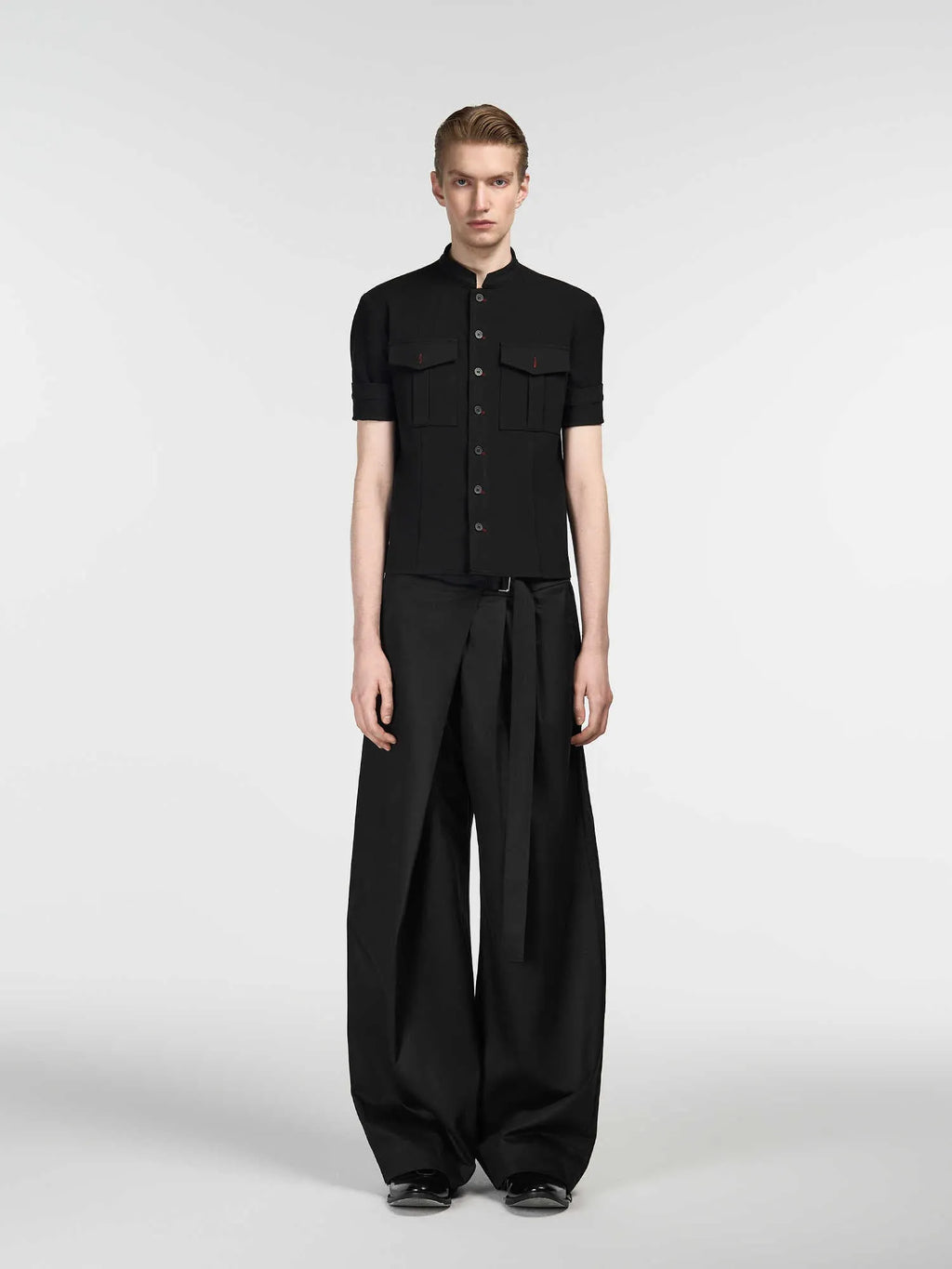 Black straight-leg trousers with a single front pleat and adjustable waistband, laid flat.