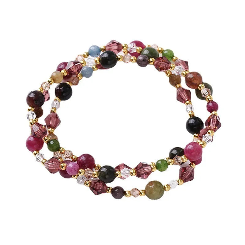 Adjustable bracelet with tourmaline, strawberry quartz, and amethyst crystals in a three-ring design.