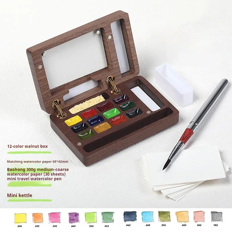 Mini walnut wood watercolour paint box open to show pigment pans with leather carrying bag