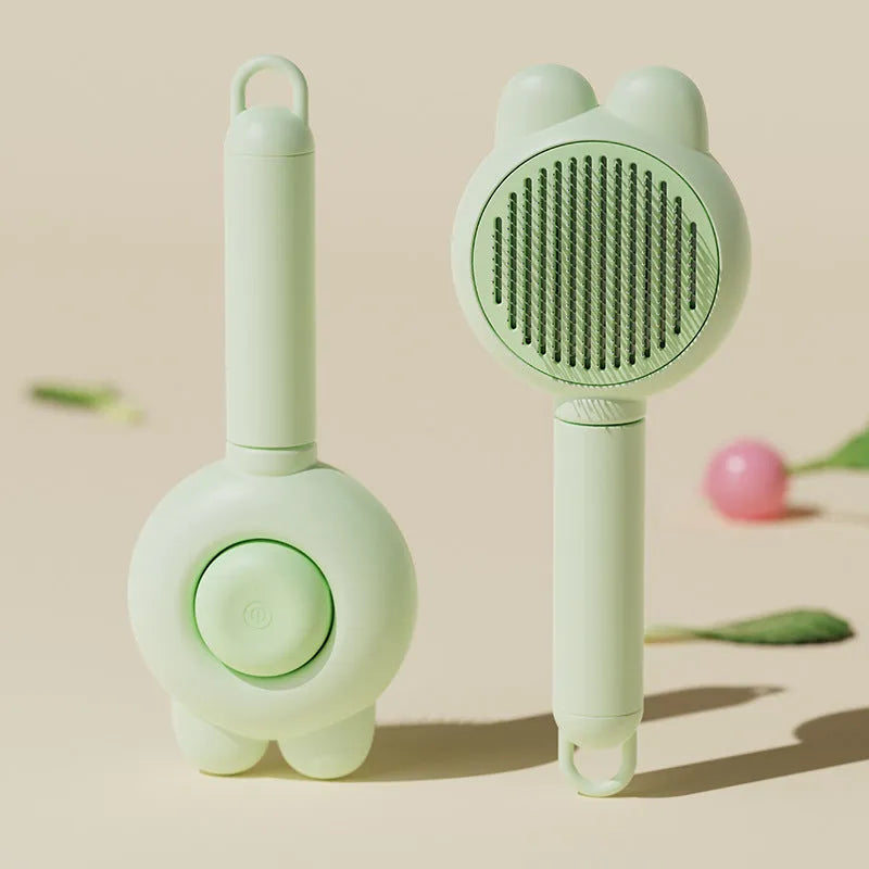 Self-cleaning pet grooming brush with green handle and stainless steel comb, showing the one-click release button.