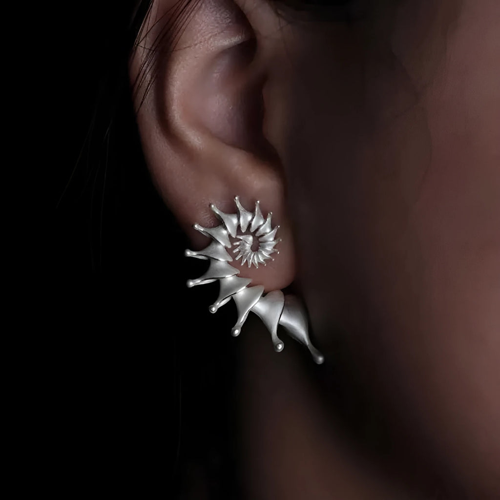 A pair of matte finish conch stud earrings with an exaggerated three-dimensional and irregular design.