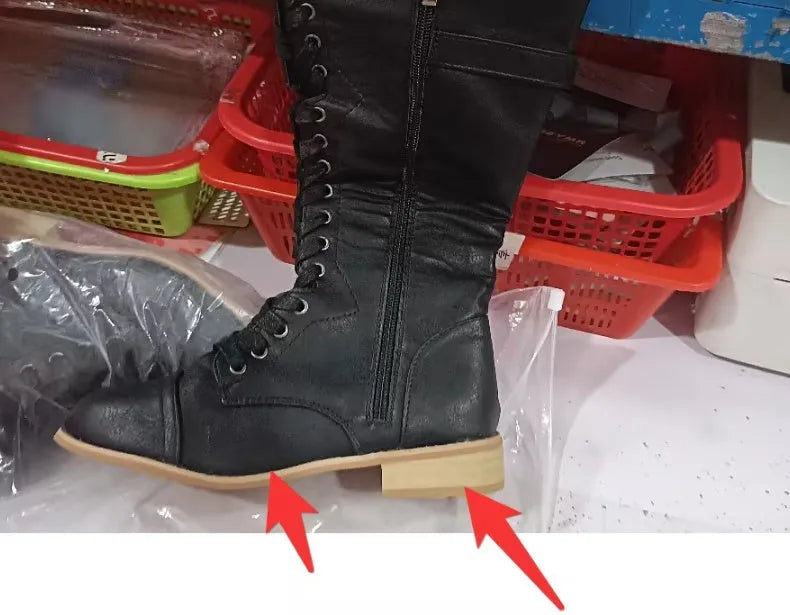 Women's black knight ankle boots with a cross-strap design across the front.