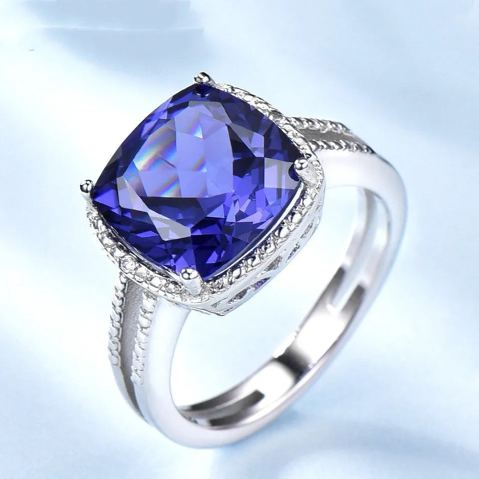 Women's sterling silver ring with a blue tanzanite gemstone on a polished band.