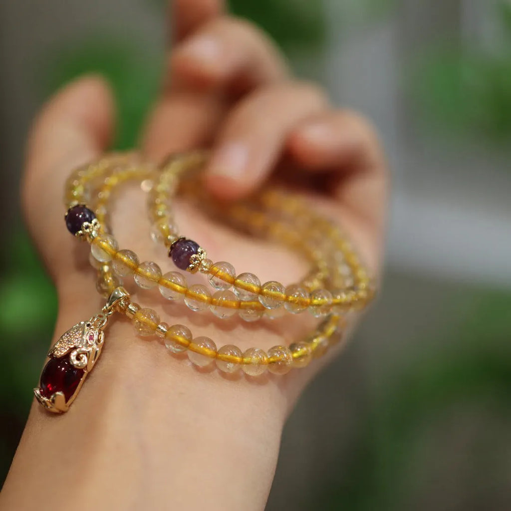 Natural rutilated quartz bracelet with gold rutile inclusions and Chinese style gold accent beads