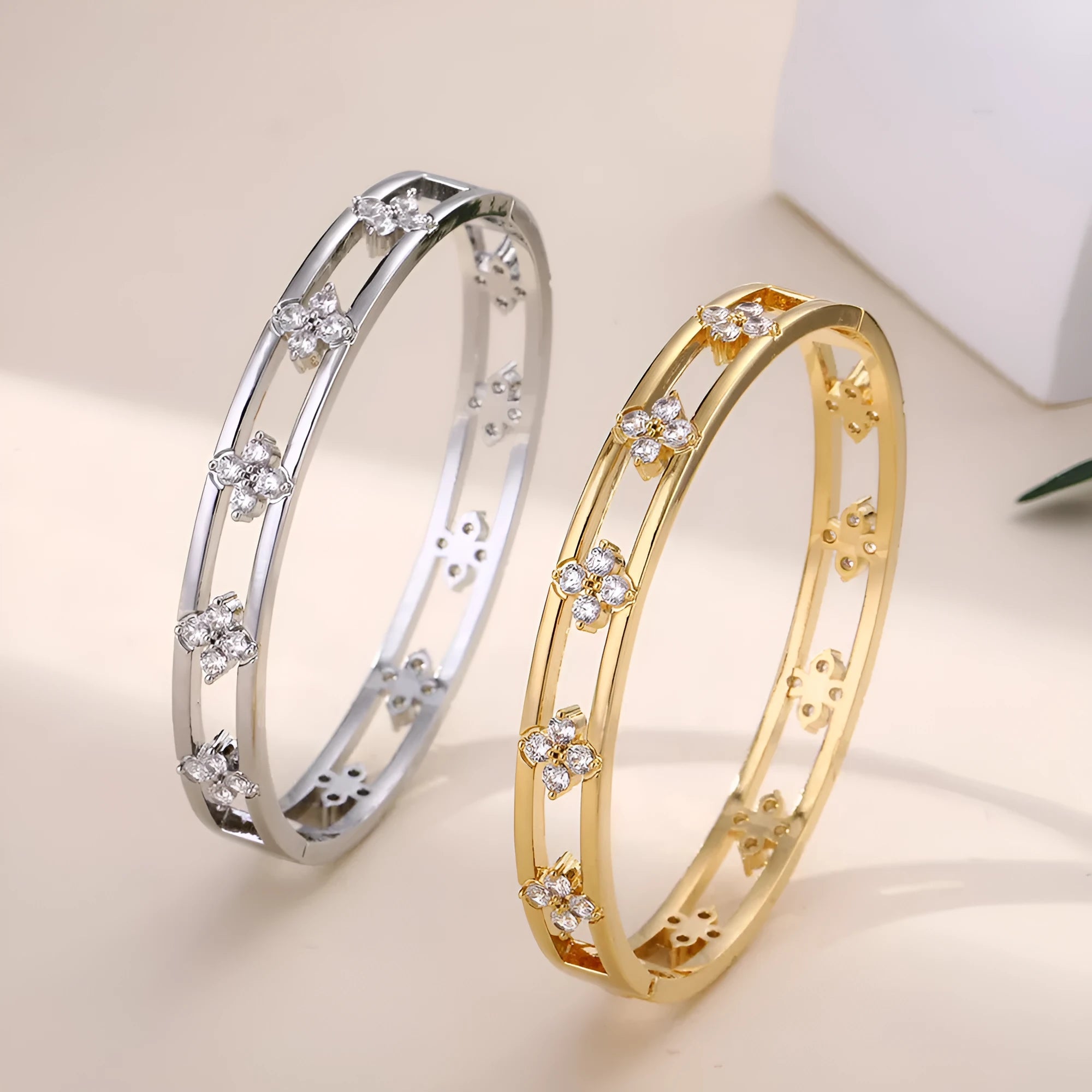 Women's hollow bracelet with four-leaf clover charm and zircon inlay detailing on copper-plated gold